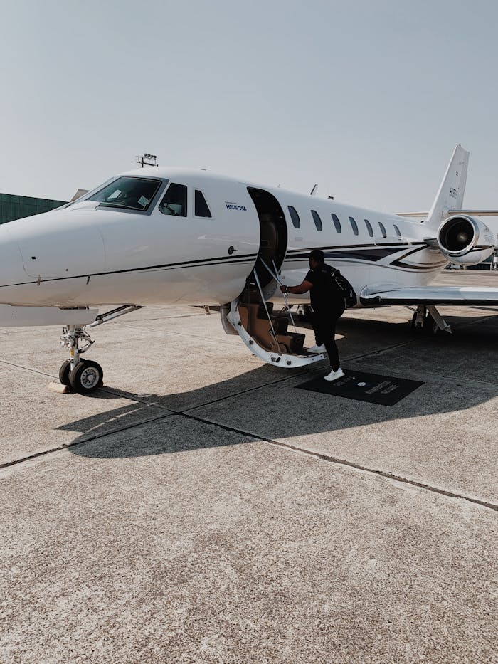 Person boarding a private jet at an airport in Guatemala City on a sunny day.
